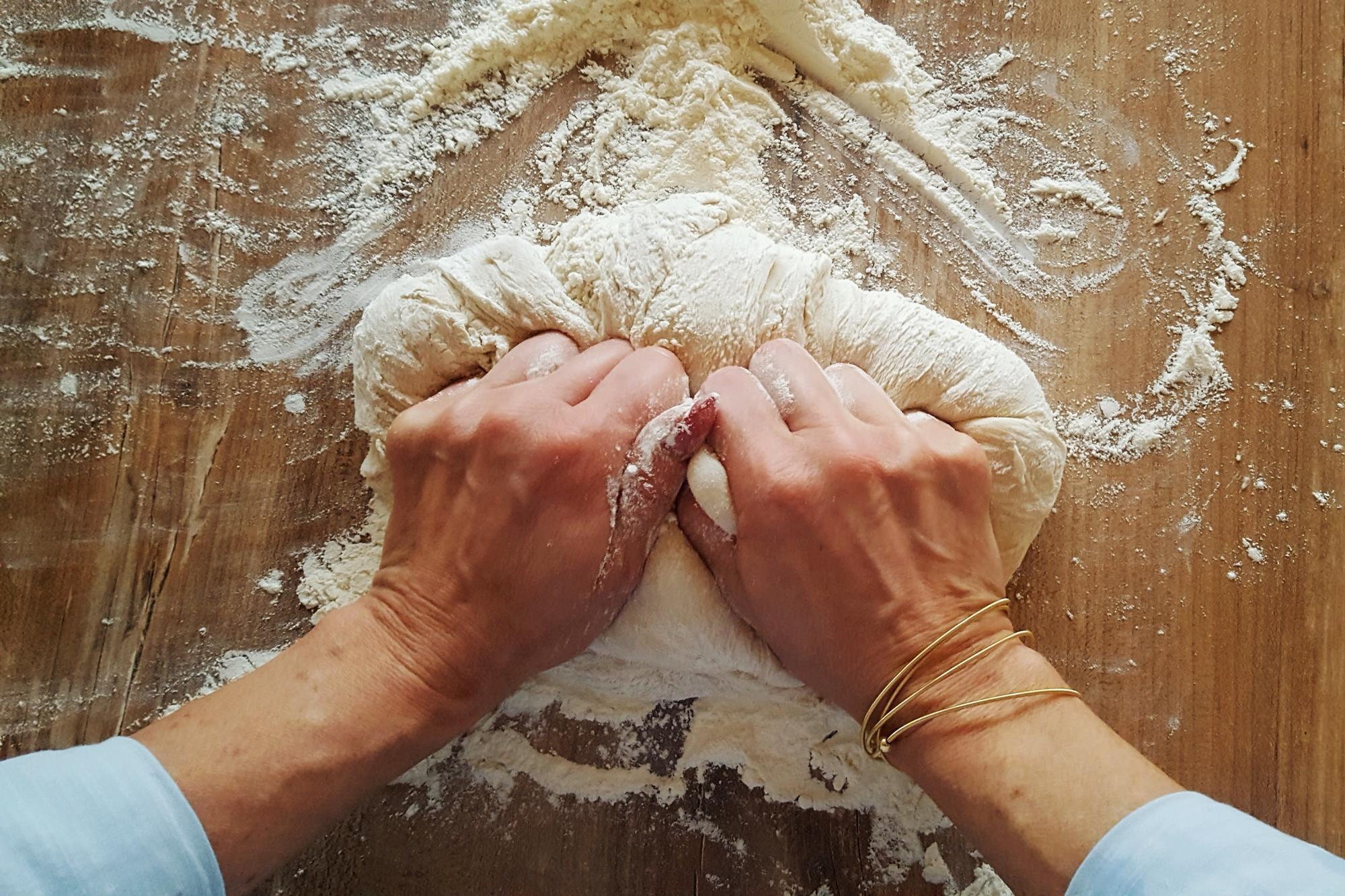 Dettaglio di mani che impastano