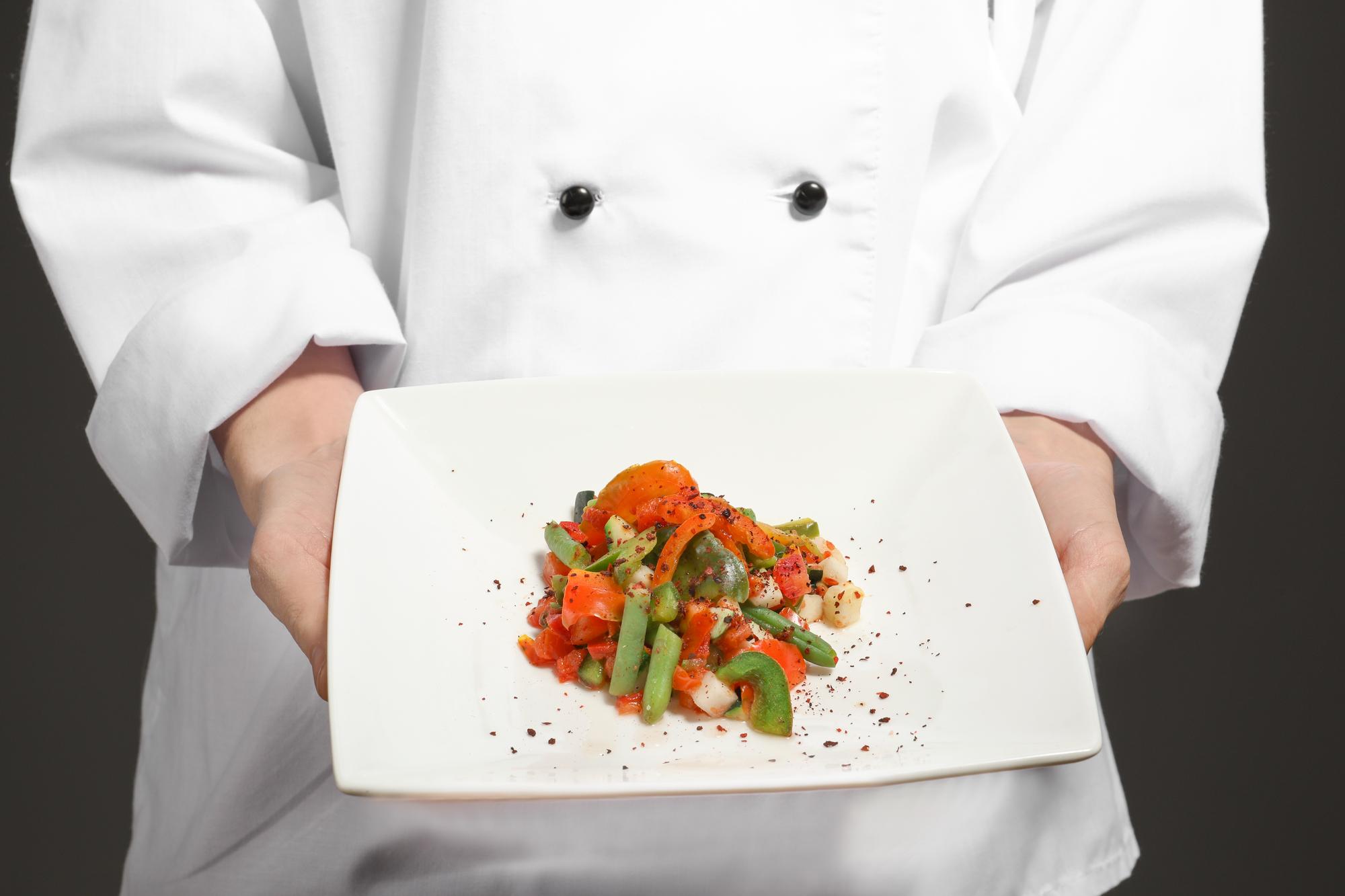 Chef che impiatta un piatto caldo con attenzione ai dettagli